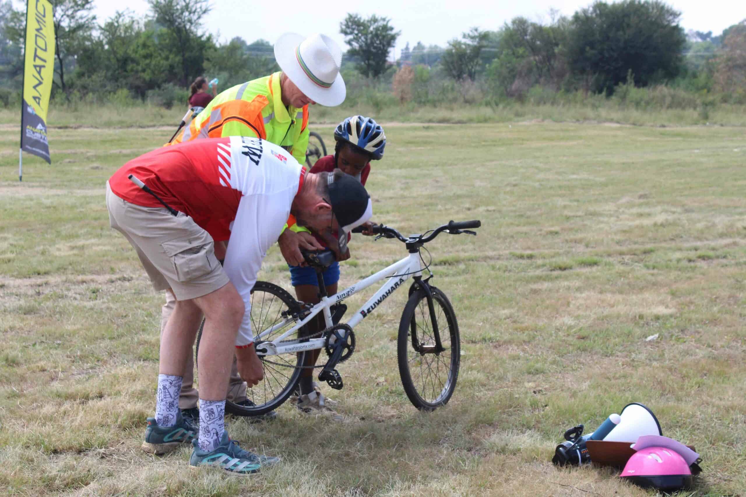 A picture that says a thousand words. Attie Koekemoer and Pierre Fourie helping a young cyclist before the start of the Parys Wetland Park Mountain Bike challenge. 