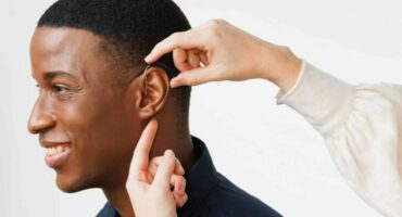 'n Oudioloog doen 'n passing van 'n gehoorapparaat.