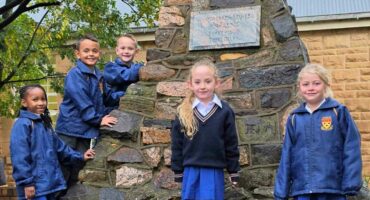 Van die graandeens van Primêre Skool Parys by die klipstapel-monument naby die skoolsaal van Hoërskool Parys. Hulle sal in hul matriekjaar die boodskappe lees wat 100 jaar gelede deur matrikulante in die monument geplaas is. Foto: Liezl Scheepers
