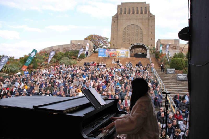 Chanie Jonker, musiekregisseur van Gé Sing: Hoor my Lied!, op klavier met die Voortrekkermonument in die agtergrond. (Foto: Niël Langner)