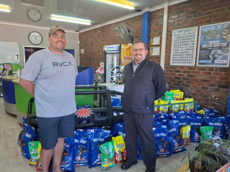 Christo Prinsloo van Parys Bande point-S oorhandig die meer as 4 000kg honde- en katkos wat vir die plaaslik DBV ingesamel is, aan Brendin Strauss.