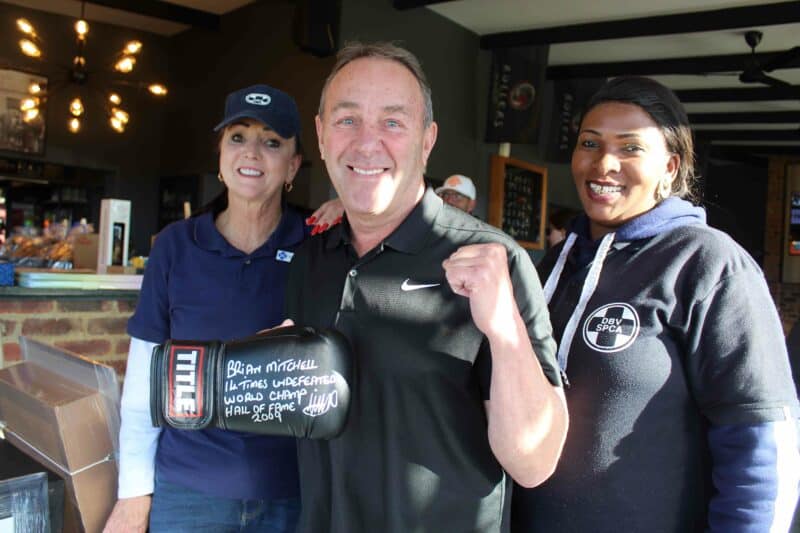 Die bokdlegende Brian Mitchell, saam met Diane Snyman en ? by die veilingsgeleentheid wat na afloop van die gholfdag gehou is.