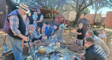 Kinders en hul ouers maak saam stokbrood om die kampvuur in die Lewende Laer. (Foto: Du Preez de Villiers)