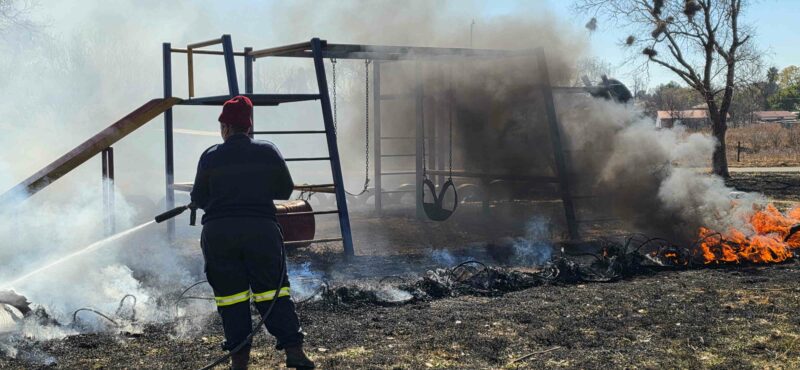 Personeel van Ngwathe se Brandweer en Reddingsdiens besig om die brand te blus in die speelpark in Eerstelaan. Foto: Liezl Scheepers