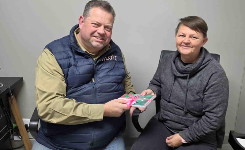 Pastoor Rinus van Sandwyk oorhandig die boekprys aan Wendy Kruger, die Julie-wenner van die maandelikse Bybelblokraai. Foto: Liezl Scheepers