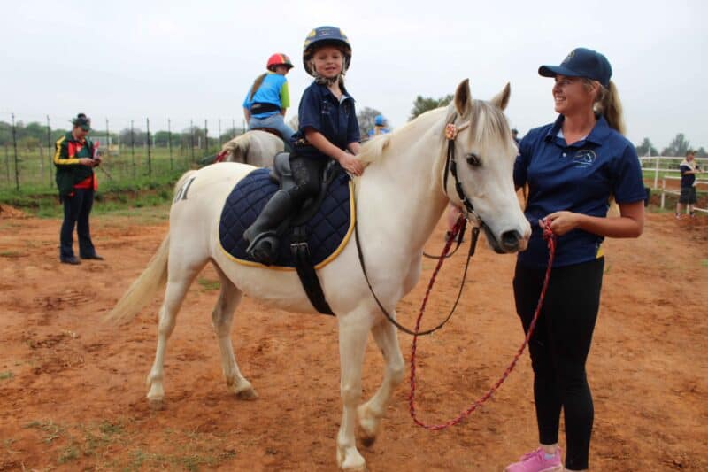 Die 4-jarige Amelia Wentzel ry al perd vandat sy 2 jaar oud is en is een van die jongste deelnemers by die kampioenskap. Amelia is op die rug van Jasmin. By haar is mamma Judith Wentzel. Foto: Liezl Scheepers