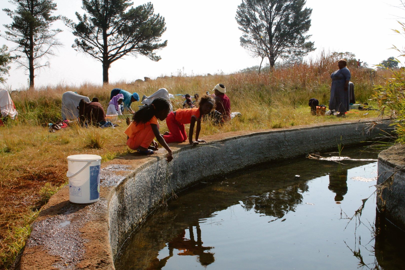 Children and women at the polluted pond that was not only used for drinking water, but also for washing clothes in Blyvoor during the past week.