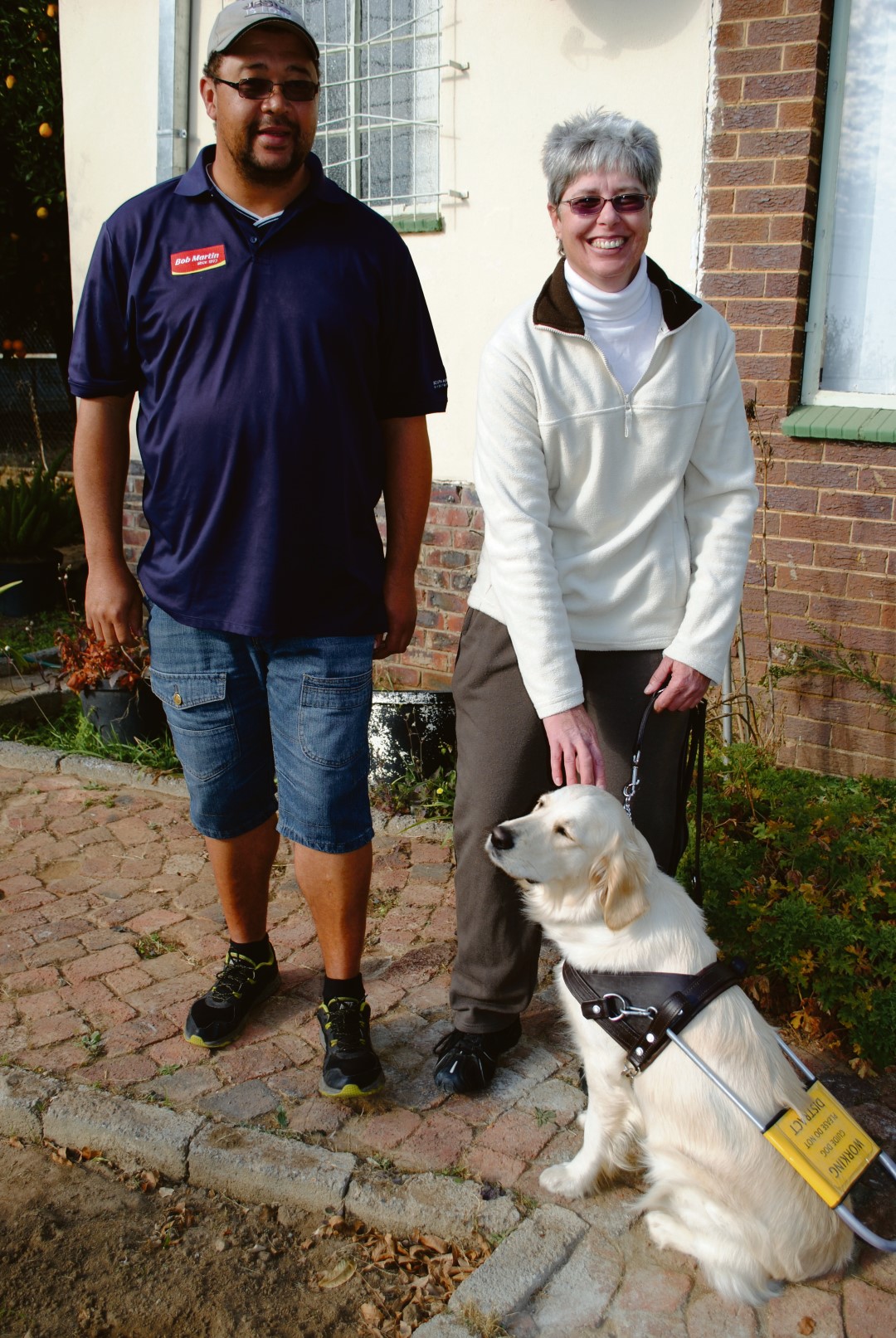 Anna Jordaan en haar kameraad, Venice wat nou haar oë in Vredefort se strate is. By haar is Joel van Stavel, die instrukteur van die Gidshondvereniging wat Venice opgelei het. Die Gidshondvereniging kan geskakel word by 011 705 3512.