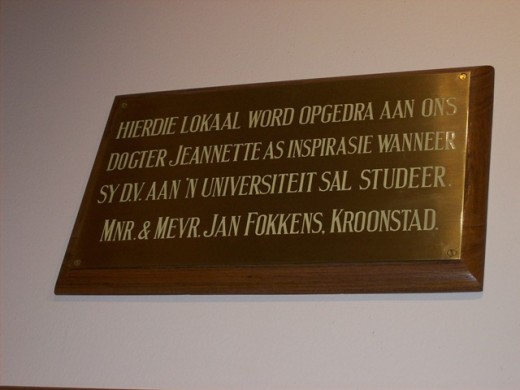Die uitstalling in die NWU Museum sluit talle van die bronsplate in wat 1930’s in die Hoofgebou aangebring is om persone wat geld geskenk het vir die oprigting van die gebou te herdenk. Jeanette Fokkens se ouers het aan die PUK geld geskenk toe sy nog baie klein was, in die hoop dat hulle dogter later sou studeer. Jeanette was in die vyftigerjare ’n student aan die PU. Foto: Lennie Gouws