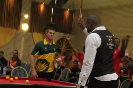 The winning moment as Lebohang Maseko lifts his pool cue in victory.