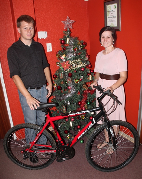 Christo Schoonbee oorhandig 'n fiets aan Maryke van Heerden van die Herald.