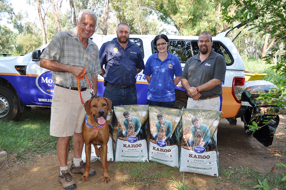 Gerald van der Merwe, eienaar van Berts Bricks, met sy hond Caesar, Andries Venter (bestuurder van PAWS), Natacia Maree (Berts Bricks) en Brian Kearney van Montego.