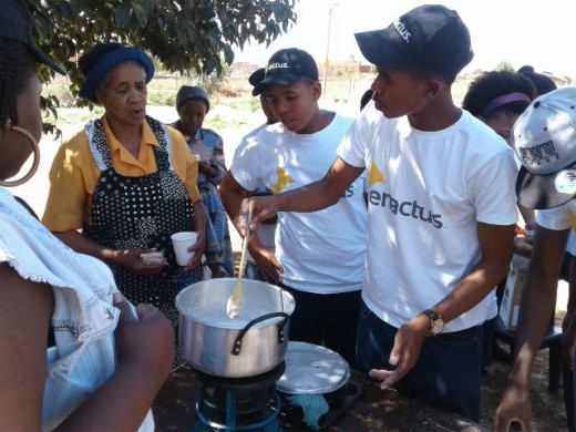The members of the Enactus team showing elderly women how to make the soap.  