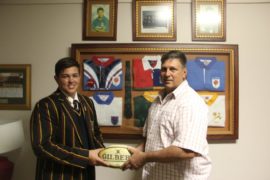 Jannie Claassens Junior en Jannie Claassens senior staan by een van laasgenoemde se rugby memorabiliastukke.