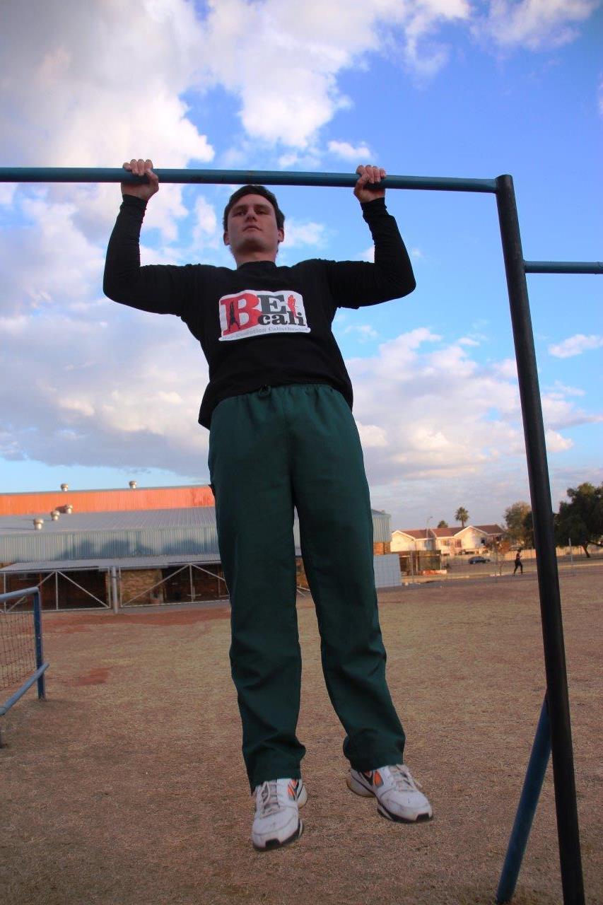 Erich Wiese showcasing his skills on the bar with a pull-up.