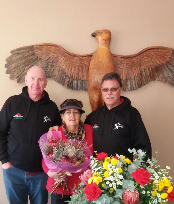 Irene Seymore ontvang ‘n bos blomme na haar laaste Coke Netbaltoernooi. Saam met haar is haar man, Daan Seymore (oud-onderwyser van Volkies) en waarnemende hoof van Volkies, Gerhard Swart (links).