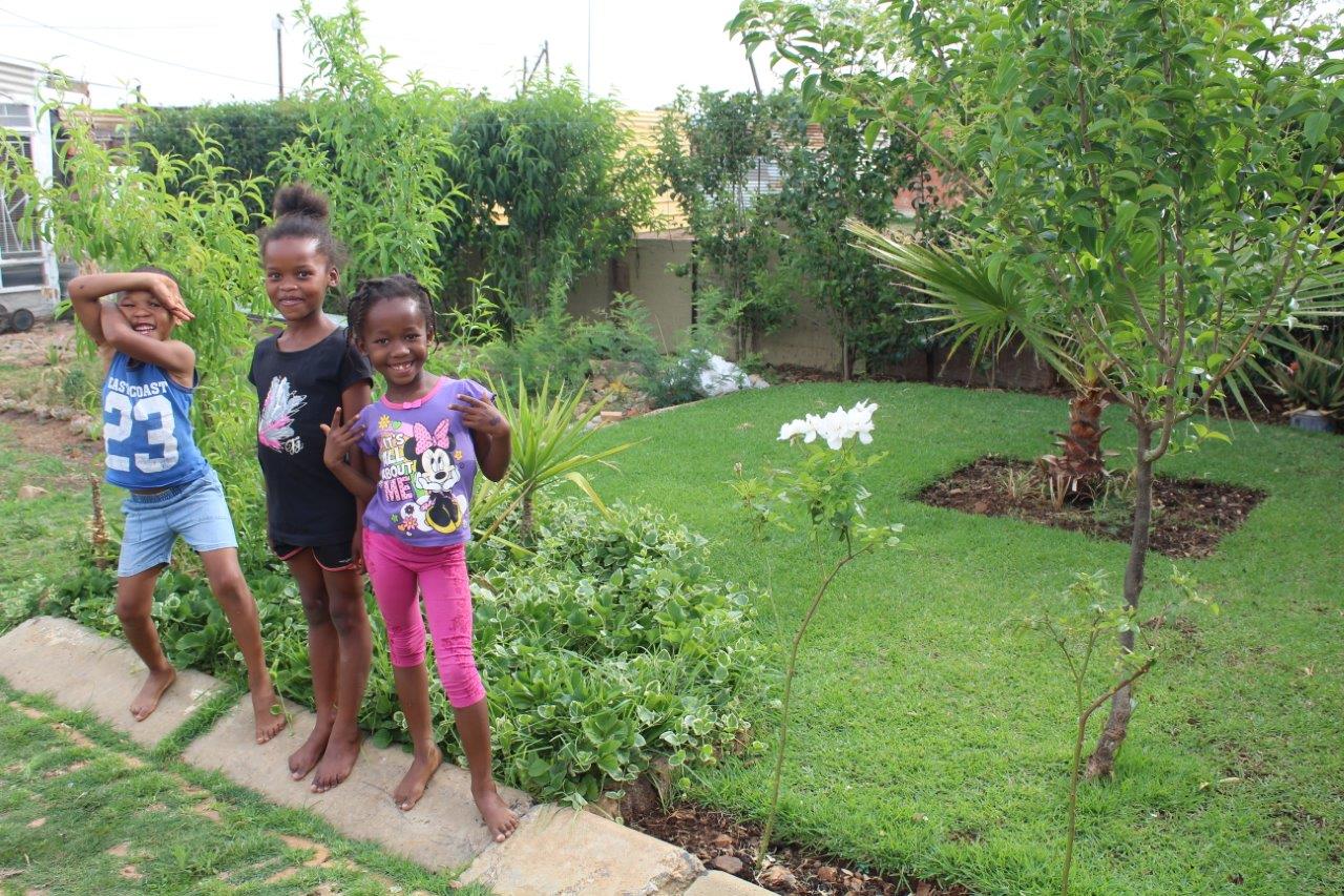 Thabo se drie susterskinders staan in sy pragtige tuin. Foto’s: Marianke Saayman