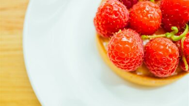 Sweet dessert custard tart with raspberry on top in white plate