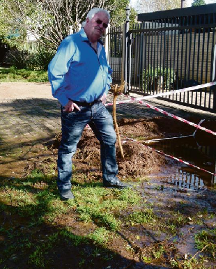 Clr Philip Nothnagel in front of the home in Danie Theron Street, Vanderbijlpark, where the results of an enormous water leak can clearly be seen.