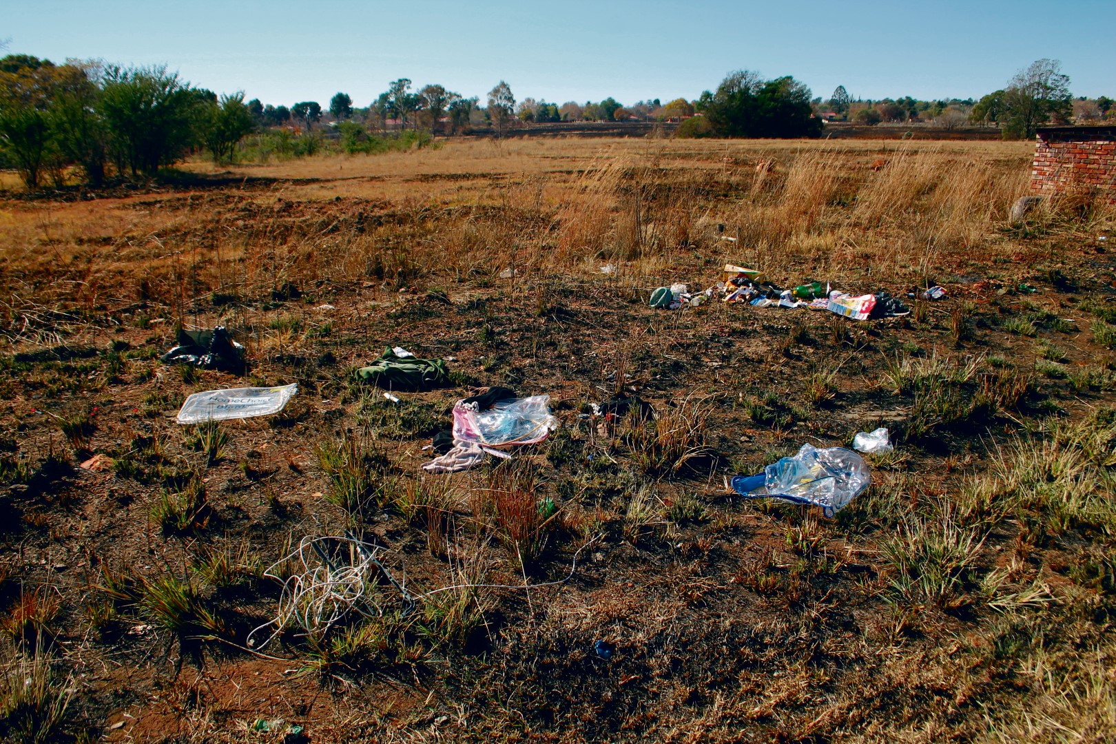 Van die aaklige gemors het steeds die week in die half uitgebrande veld gelê.