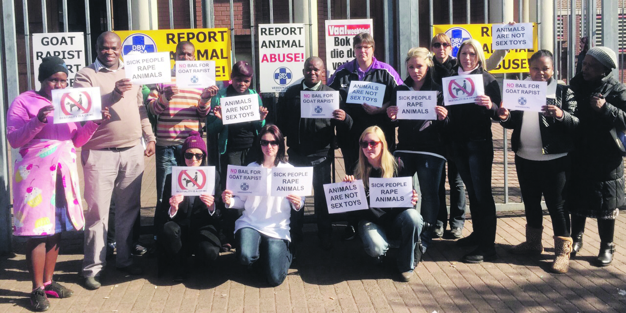 Lede en ondersteuners van die DBV buite die hof met hul plakkate en baniere. Foto: Moleboheng Chaha