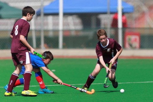 Darian Schreuder van die Laerskool Emfulenipark se eerste hokkiespan ontduik ’n speler van Lichtenburg tydens die Laerskool Risiville se Super8-toernooi wat onlangs in Vanderbijlpark plaasgevind het. Sy spanmaat Juan van der Berg staan nader om te help.  Foto: Ettienne van Rensburg 