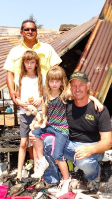 Ganan Doodhnath van Gamula Construction staan agter Maarline. Hy en vriende gaan die Pretorius-gesin se huis herbou. Regs is Joggie Joubert saam met Nadine. Joggie het R10 000 aan die gesin geskenk. Foto: Jannie du Plessis