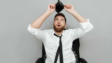 Frustrated surprised bearded man in white shirt showing empty wallet