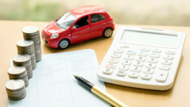 Coins stack in columns on saving book and car on finance concept