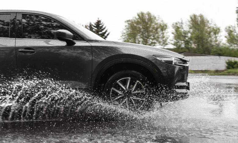 Modern car driving outdoors on rainy day