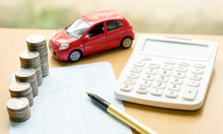 Coins stack in columns on saving book and car on finance concept