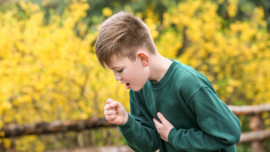 Boy having asthma attack outdoors on spring day