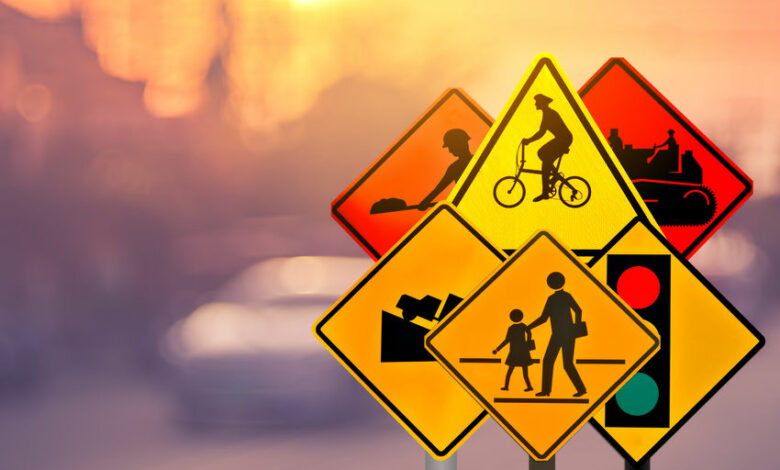 Set of traffic warning sign on blur traffic road with colorful bokeh light abstract background.