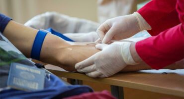 A person getting blood from a person's arm.