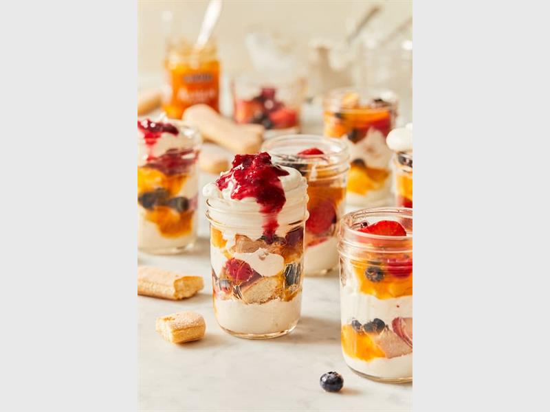 This easy, no-bake fruit trifle combines sponge cake, jelly, custard, fresh fruit, and whipped cream for a delicious and visually stunning festive treat.