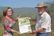 A file image of Secretary of Friends of Bisley Nature Reserve (FoBNR) Marlene Bell and chairperson of FoBNR Peter West hold up the 2026 Bisley Nature Reserve Calendar, while the reserve's curious giraffe look on. Photo: Moeketsi Mamane