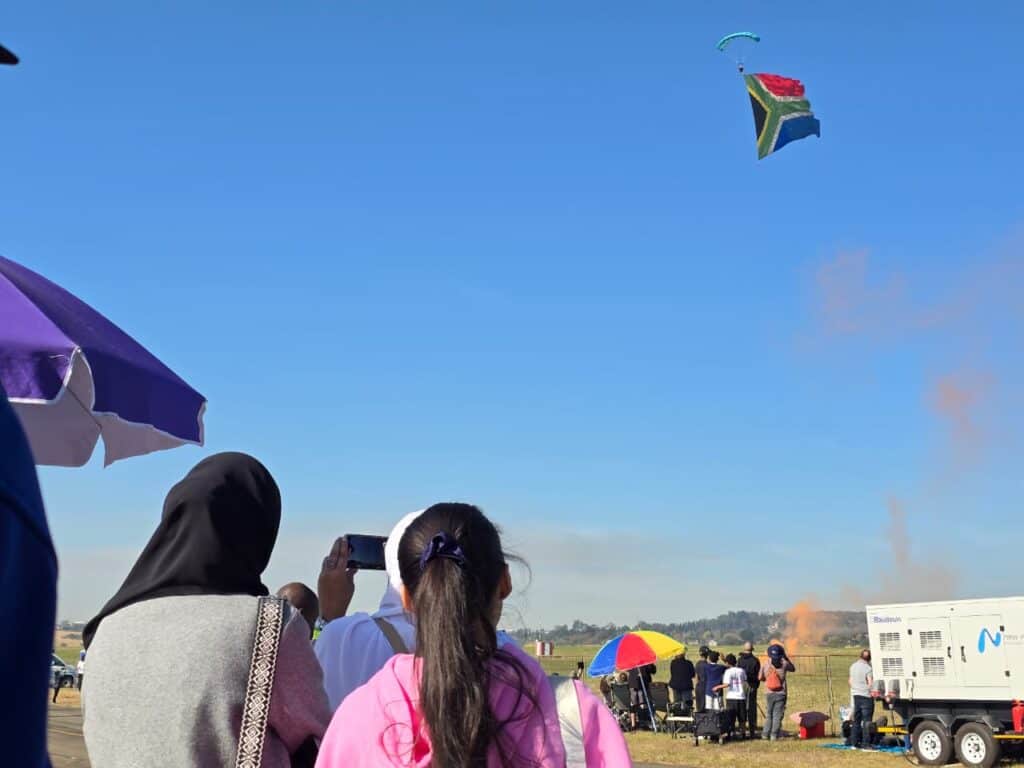A jumper makes his way gently to the ground as the South Africa flag flutters behind him. Photo: Moeketsi Mamane