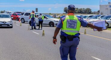 A national traffic police officer directs an oncoming vehicle to move to the side of the road at a road stop. Photo Road Traffic Management Corporation