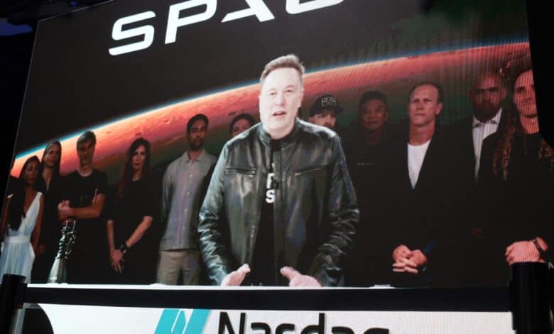 NEW YORK, NEW YORK - JUNE 12: SpaceX founder and CEO Elon Musk speaks via video at the Nasdaq Marketsite in Times Square during the launch of the SpaceX initial public offering (IPO) on the Nasdaq on June 12, 2026, in New York City. SpaceX, a rocket-making company, began trading Friday under the ticker SPCX following the largest initial public offering ever. Owner Elon Musk, who’s also CEO of Tesla and celebrated from a rocket launch site in Florida, is set to become the world’s first trillionaire. Spencer Platt/Getty Images/AFP (Photo by SPENCER PLATT / GETTY IMAGES NORTH AMERICA / Getty Images via AFP)