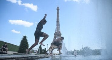 People jump in the Trocadero Fountain near the Eiffel Tower during a heatwave in Paris on June 22, 2026.