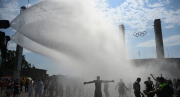 Police use water cannon to spray people with water as the arrive at the Olympic stadium for a concert of US singer Bruno Mars on June 28, 2026, in Berlin, as the German capital is expected to reach temperatures around 40 degrees Celsius during a heatwave in Europe.