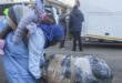 A Malawian woman repatriated from South Africa pushes her luggage while holding a girl on her back at Kamuzu stadium, the country's receiving camp on Thursday. Photo: AFP