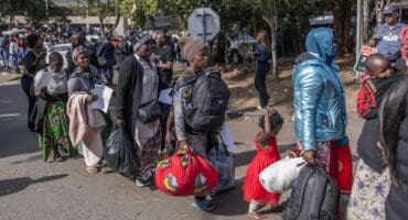 Migrants stand in a queue to board the first of eight buses at the Sherwood Park in Durban yesterday to travel back to Malawi. Photo: RAJESH JANTILAL / AFP