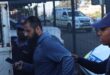 Yusuf Omar, Omar Motor Den in Emalahleni, is photographed being taken to the back of a police vehicle by an unnamed police officer. Photo: SIU