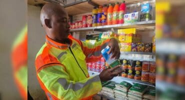 Mfolozi Mayor Xolani Bhengu inspects a longlife milk bottle to ensure it has not gone passed its expiry date. Photo: Supplied