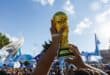 A replica of the FIFA World Cup is lifted by an Argentina's fan during a gathering at Mill Creek Park on the eve of the World Cup quarterfinal match between Argentina and Switzerland, in Kansas City, Missouri, on July 10, 2026. (Photo by Austin Johnson / AFP)