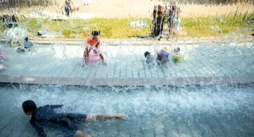 Children cool off in a public water playground at a park in Edogawa district of Tokyo on July 23, 2026.