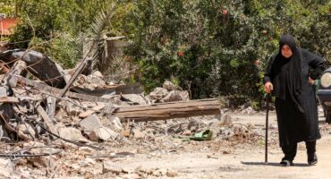 A woman walks past a destroyed building in the village of Zawtar al-Gharbiyeh in southern Lebanon on July 26, 2026.