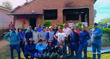 Representatives from Msunduzi Municipality and partner organisations stand outside the family's newly restored home in Imbali Unit 18 following the Mandela Day renovation project. Photo: Supplied