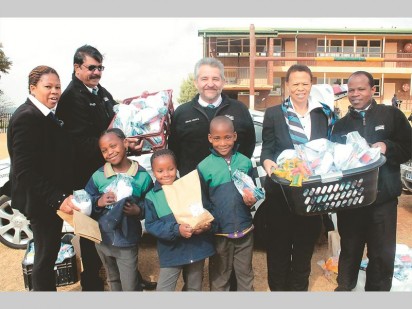Some of the staff members from Harcourts Rhino with the pupils from Lewisham Primary. At the back from the left is Thato Mahopo, Harry Singh, Mauro Mosca, Deogracia Mahopa and Funeka Hermanis. In the front from the left is Grade 2 pupils Refilwe Nkosi (8), Kealeboga Pule (8) and Tumelo Maku (9).
